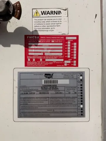 FMCSA annual vehicle inspection label and manufacturer data plate showing DOT compliance