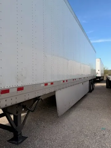Full side profile view of 53-foot dry van trailer showing aluminum body, landing gear, and tandem axles