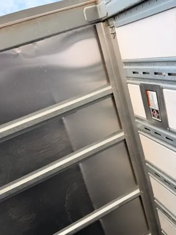 Interior door frame showing aluminum construction and safety decals