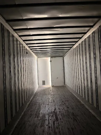 Full-length interior view looking toward front bulkhead showing wood floor condition and cargo space